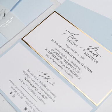 Niebieskie zaproszenie ślubne z czarnym tekstem i złotą podklejką