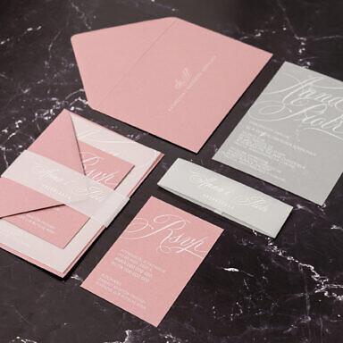 Różowe zaproszenie ślubne z białym drukiem na kalce i bilecikiem
