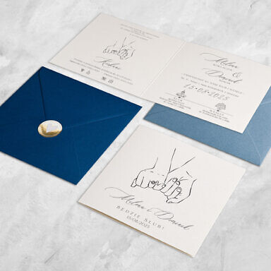 Zaproszenie ślubne splecione ręce młodej pary z granatową kopertą i złoconą naklejką serce